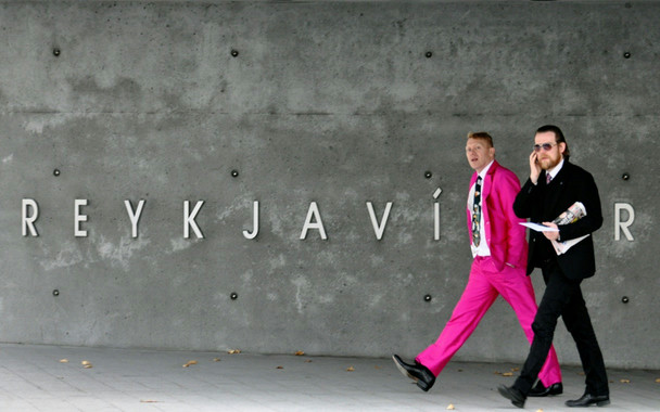 Jón Gnarr walks out of Reykjavík City Hall in a pink suit.