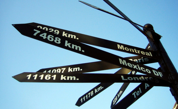 A signpost showing the direction and distance of world cities