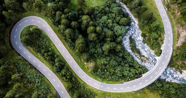 A view down to a winding road crossing a fast river