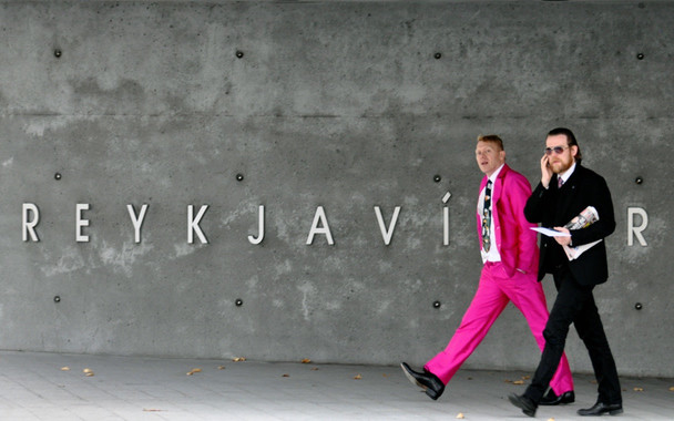 Jón Gnarr walks out of Reykjavík City Hall in a pink suit.